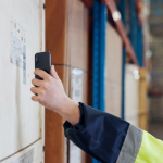 Construction worker in hi-vis scanning a tool asset label with a phone to track every asset